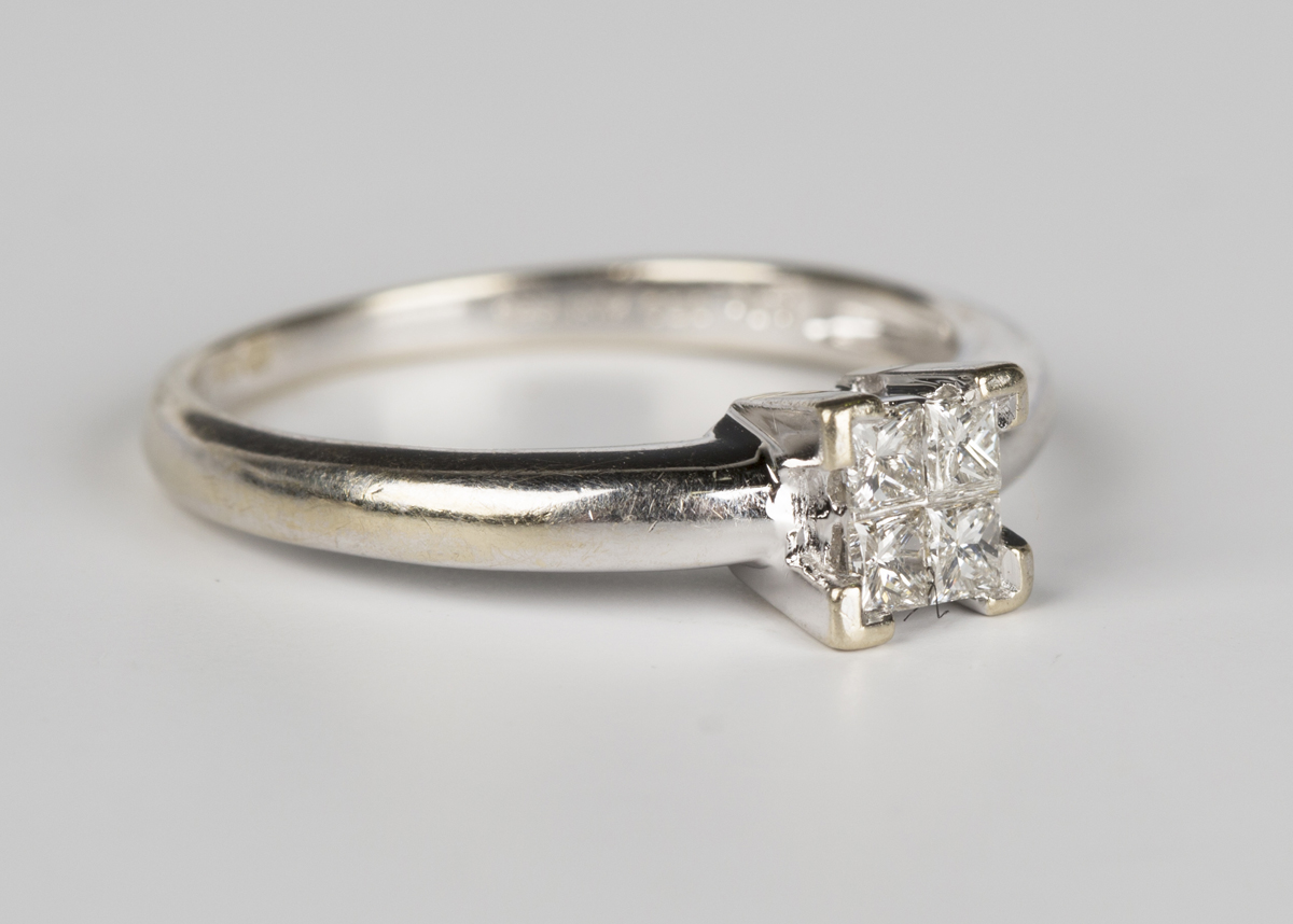 An 18ct white gold and diamond ring, mounted with four princess cut diamonds, detailed '0.20 18K