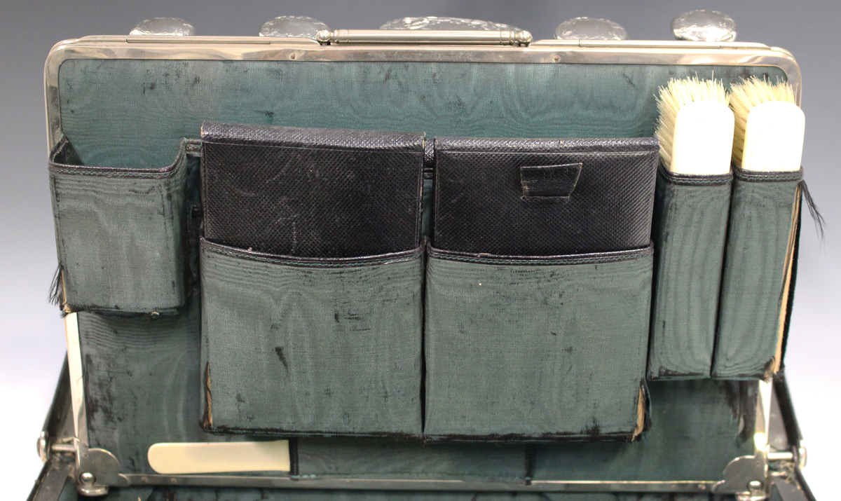 An Edwardian black leather Gladstone vanity bag, the interior fitted with five silver and cut - Image 4 of 5