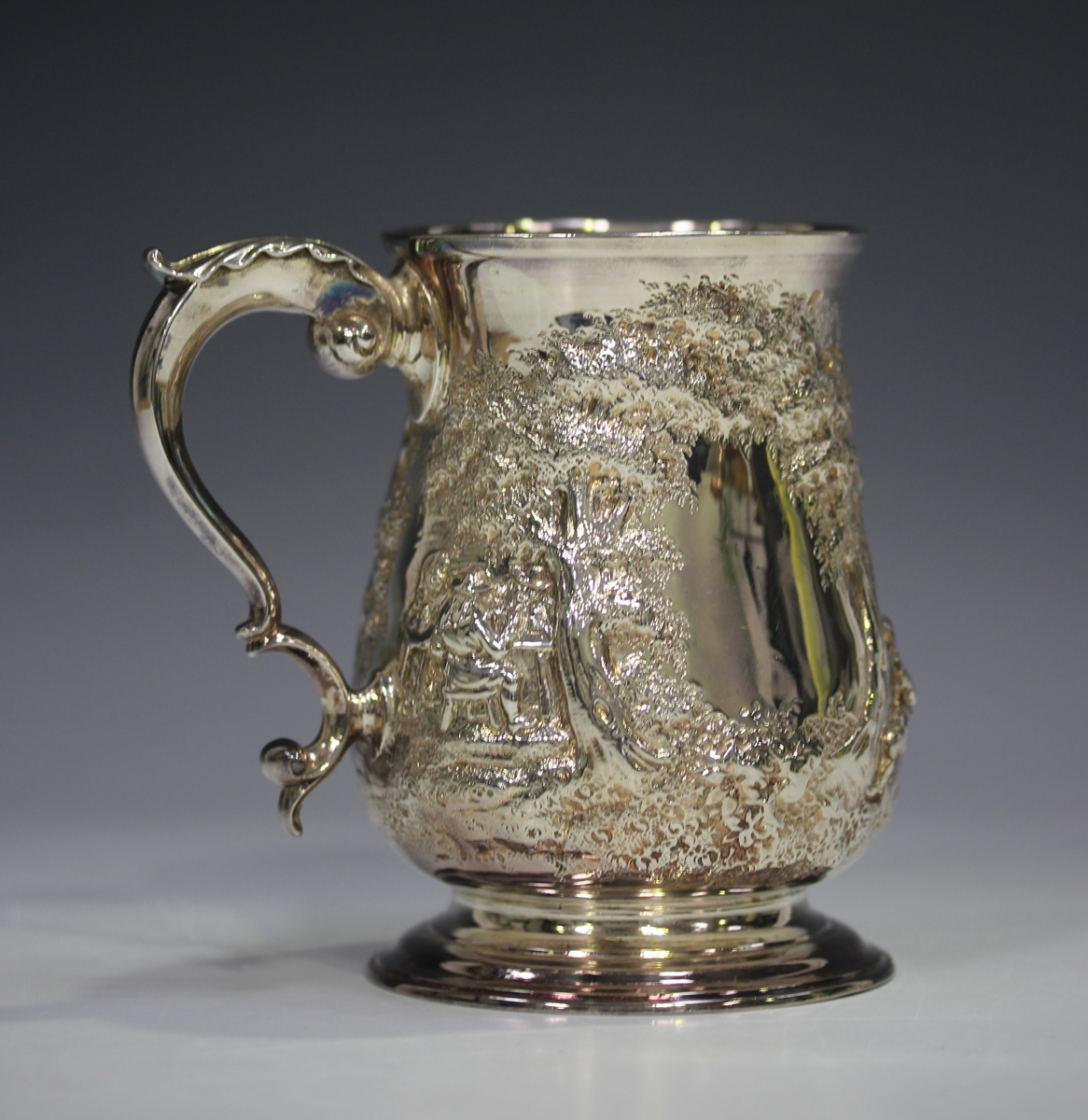 A George III silver tankard, the baluster body later embossed with a scene of figures seated and