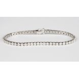 A white gold and diamond bracelet, claw set with a row of circular cut diamonds, on a snap clasp,