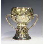 An Art Nouveau silver three-handled cup with all-over hammered decoration, the globular bowl and