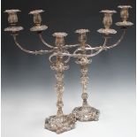 A pair of George III silver candlesticks, each rococo scroll moulded baluster stem decorated in