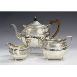 A silver faceted oval teapot and matching two-handled sugar bowl with reeded and foliate band