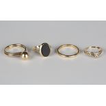 A 9ct gold and black onyx oval signet ring, a 9ct gold wedding ring, a 9ct gold ring and another