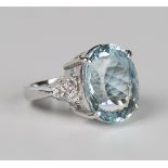 A platinum, aquamarine and diamond ring, claw set with an oval cut aquamarine between diamond set