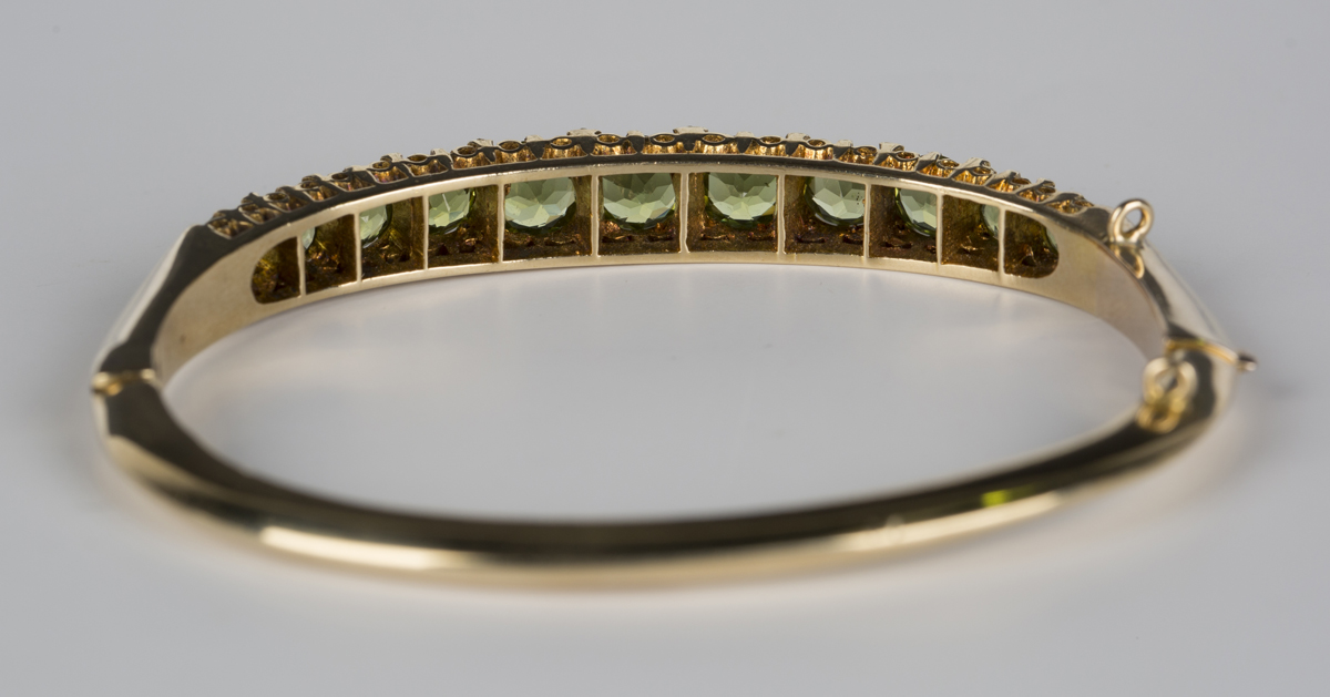 A 9ct gold, peridot and diamond oval hinged bangle, mounted with a row of eleven circular cut - Image 3 of 3