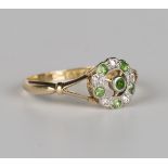 A gold, demantoid garnet and diamond cluster ring, collet set with a demantoid garnet within an