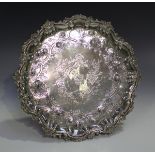 A George II silver circular salver, engraved with a coat of arms within a floral and scale effect