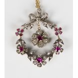 A gold backed and silver set, ruby and diamond pendant, the swing centre with a flowerhead shaped