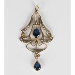 A gold, sapphire and seed pearl pendant, circa 1910, in a pierced drop shaped design, collet set
