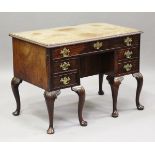 A George II mahogany kneehole desk, the crossbanded top with a carved edge above drawers and central