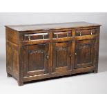 A mid-18th century provincial oak dresser base, fitted with three drawers above arched panel