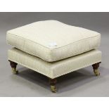 An Ashley Lawrence square footstool, on turned tapering legs terminating in brass caps and