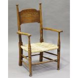 An early 20th century Arts and Crafts ash panel back elbow chair, designed by E.G. Punnet for