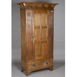 An Edwardian Arts and Crafts oak wardrobe, in the manner of Shapland & Petter, the overhanging
