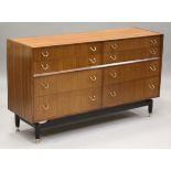 A G-Plan E. Gomme teak sideboard, the eight drawers with applied gilt brass handles, on ebonized