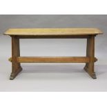An early 20th century Arts and Crafts oak window seat, the shaped top raised on reeded plank