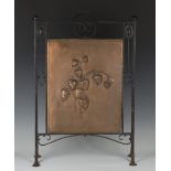 An early 20th century wrought iron and patinated copper firescreen, the copper panel worked in