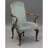 An early 20th century Queen Anne style walnut framed shepherd's crook elbow chair, raised on