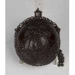 An early 19th century finely carved coconut bugbear powder flask of Napoleonic interest, one end