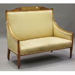 An Edwardian Neoclassical Revival satinwood showframe salon settee, the frame finely carved with