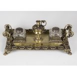 A 19th century cast brass inkstand, fitted with a central candle holder flanked by a pair of cut