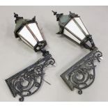 A pair of 20th century Continental cast iron wall mounted street lanterns with foliate scrolling