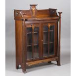 An Edwardian Arts and Crafts mahogany glazed bookcase, in the manner of Wylie & Lochhead, inlaid