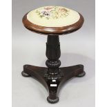 A Regency rosewood circular piano stool, the floral tapestry seat above a tulip cusp stem and