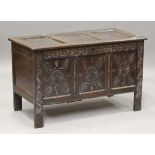 A late 17th century oak panelled coffer, the triple-panel front carved with foliate arabesques and