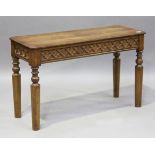 A late 19th/early 20th century Gothic Revival oak hall table, the carved blind fretwork frieze