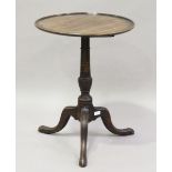 A 19th century mahogany tip-top wine table, the dished top on a turned stem and tripod legs,