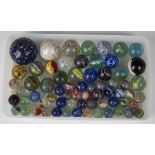 A selection of approximately sixty glass marbles, diameters ranging from 1.4cm to 4.4cm.Buyer’s