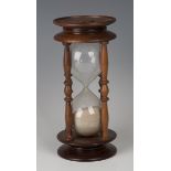 A late 20th century mahogany framed hour glass, height 26cm.Buyer’s Premium 29.4% (including VAT @