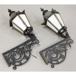 A pair of 20th century Continental cast iron wall mounted street lanterns with foliate scrolling