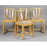 A set of four early 20th century Heals pale oak comb back dining chairs with drop-in seats,