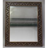 An early 20th century Gothic Revival stained softwood wall mirror with a carved tracery frame, 103cm