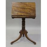 A George IV mahogany tilt-top reading table, fitted with a pair of candle stands, the ring turned