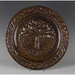 A 20th century Arts and Crafts patinated copper charger, worked with a central tree of life with