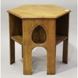 An early 20th century Arts and Crafts oak hexagonal book table, three sides pierced with teardrop