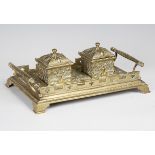 A late Victorian Gothic Revival cast brass inkstand, the two lidded inkwells flanked by spiral
