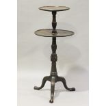 An early 20th century George III style mahogany two-tier dumb waiter, raised on tripod legs,