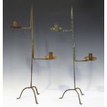 A pair of 20th century wrought iron rush light candle stands, height 70cm, together with a wrought