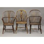 A group of three mid-19th century ash and elm Windsor armchairs, all raised on turned legs,