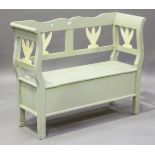 A late 20th century Swedish painted pine box seat settle with foliate back supports, on block