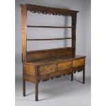 A George III North Country oak and mahogany crossbanded dresser, the shelf back and apron with