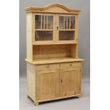 A 20th century Continental pine dresser with arched glazed top and open shelf, the base fitted