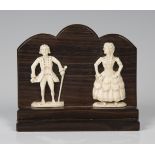 A pair of 19th century carved ivory flatback figures of a lady and gentleman, applied to a stepped