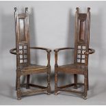 A near pair of early 20th century Arts and Crafts stained oak 'Shakespeare' armchairs, in the manner