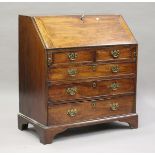 A small George III mahogany bureau, the fall-flap enclosing a fitted interior above oak-lined